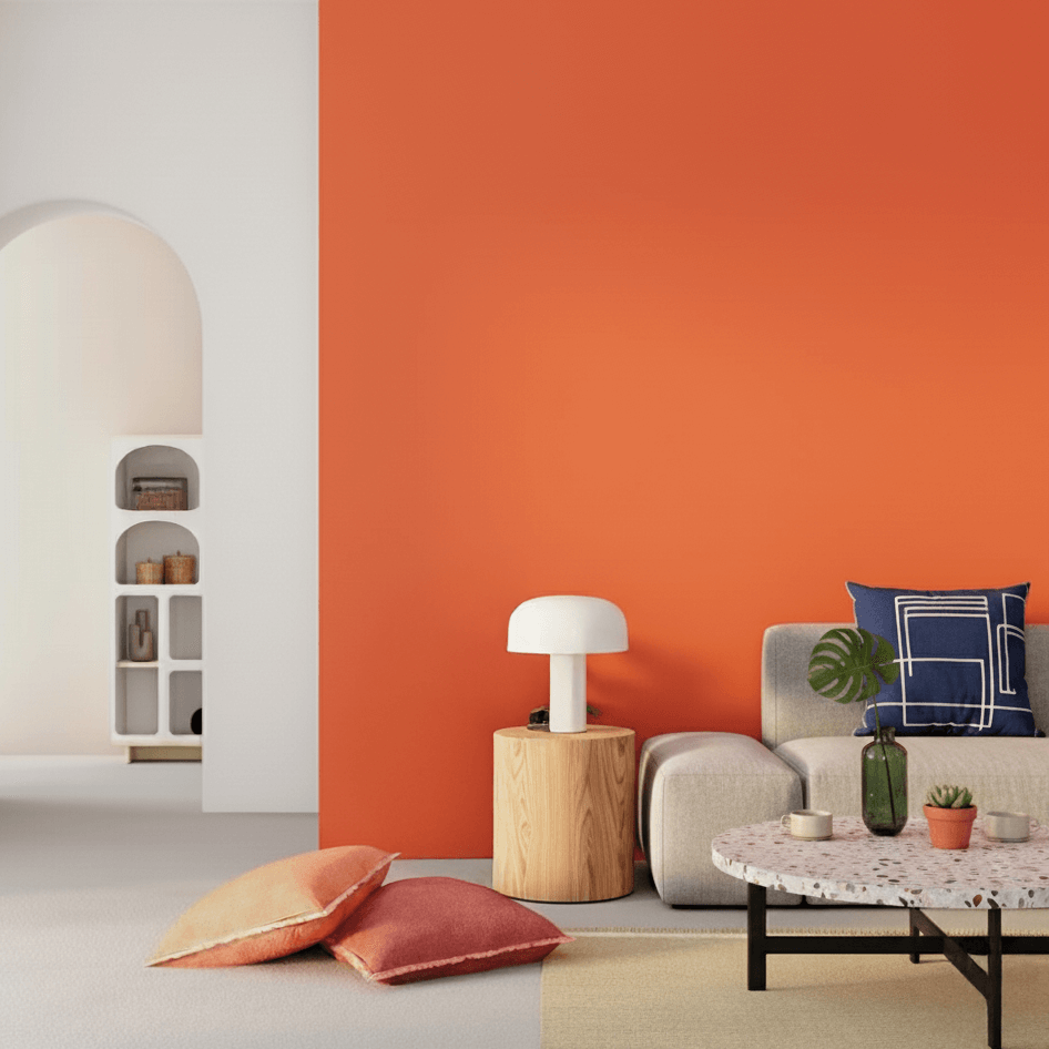 Wandfarbe orange an einer Wand in modernem Wohnzimmer mit Couch und Dekokissen.
